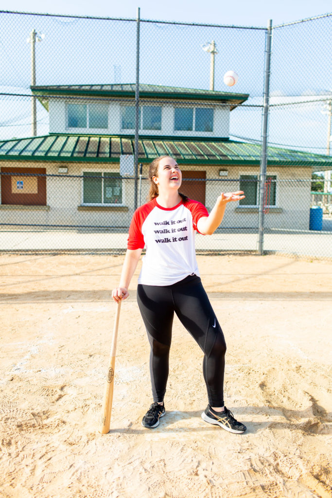 Brunette-Girl-Wearing-Charlie-Southern-Walk-It-Out-Tee-And-Nike-Workout-Leggings-With-Louisville-Slugger-Baseball-Bat-And-Baseball-At-Baseball-Field