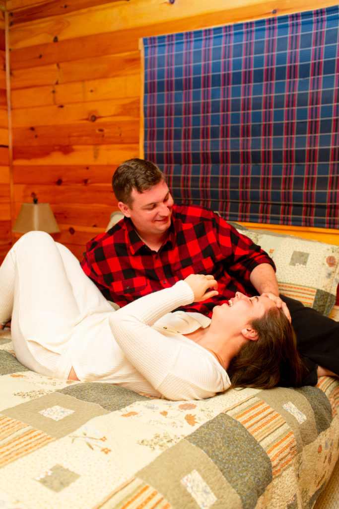man-woman-snuggling-in-bed-in-new-hampshire-cabin